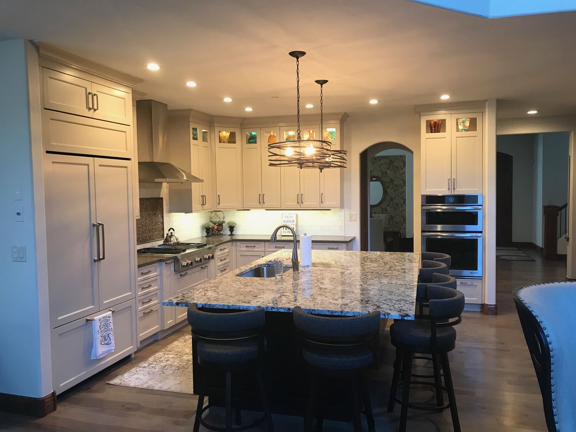 Cream shaker kitchen with a dark stone-top island and pendant lighting